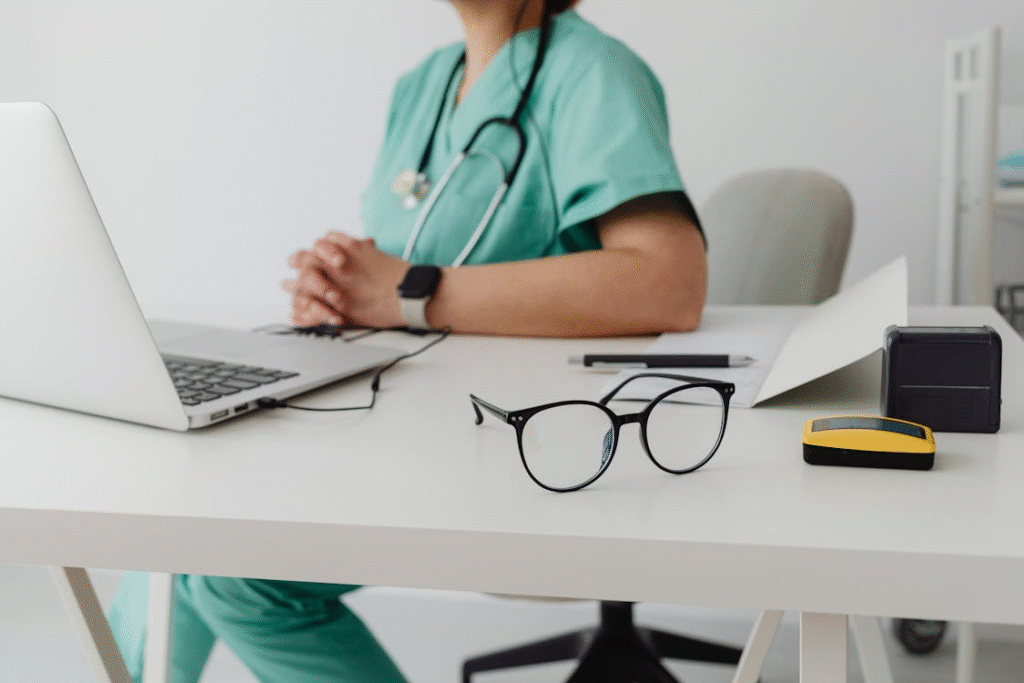 woman in blue scrub suit using macbook pro
