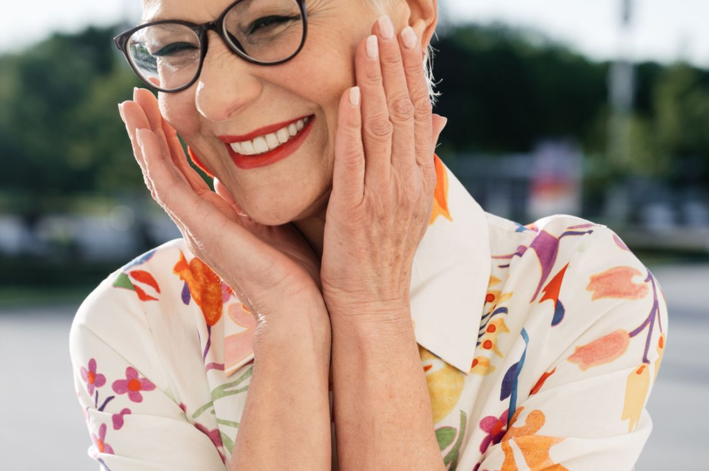 a woman smiling while touching face
